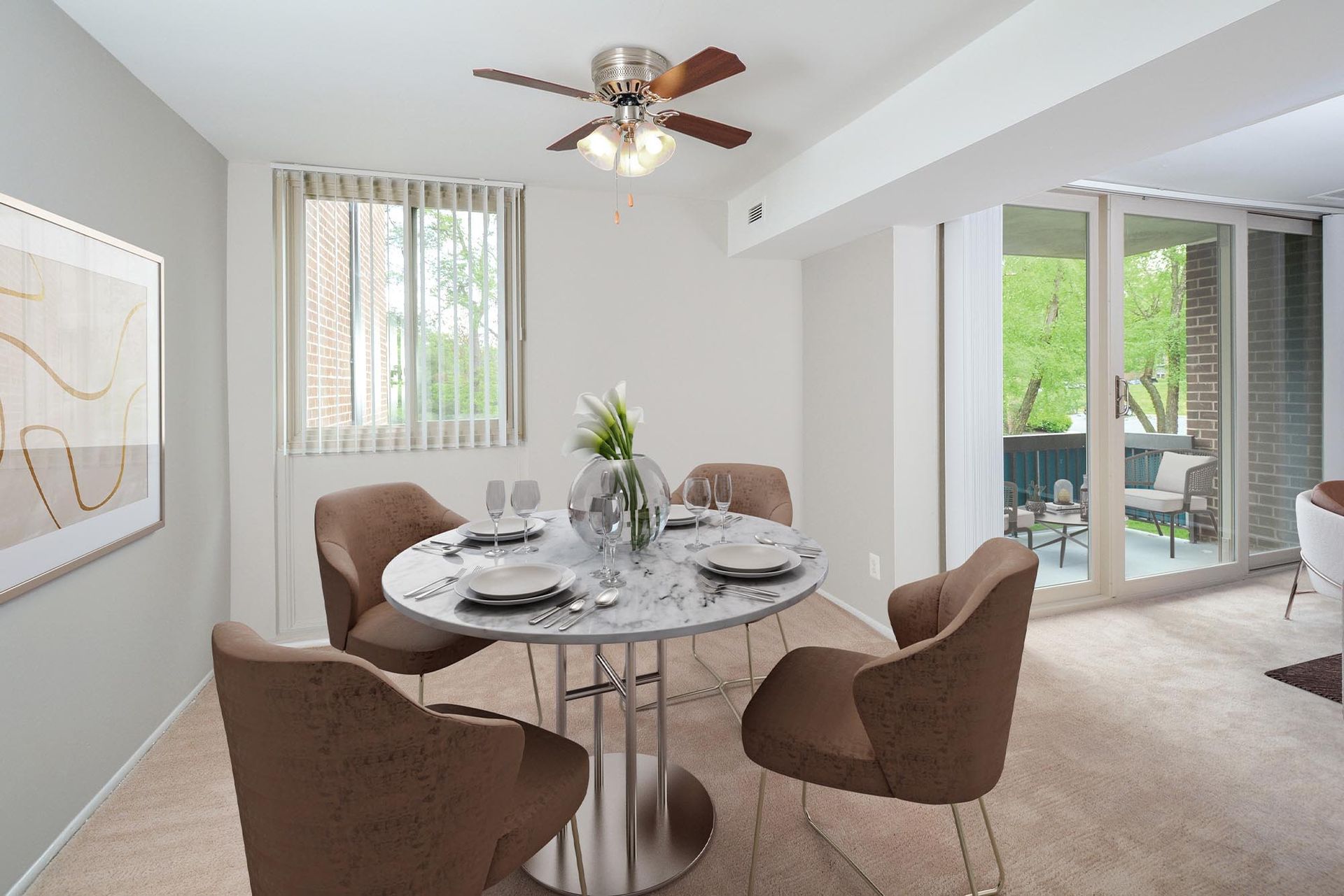 Dining room with marble table, brown chairs, and sliding glass door to a balcony at Glenmont Station in Silver Spring, MD.