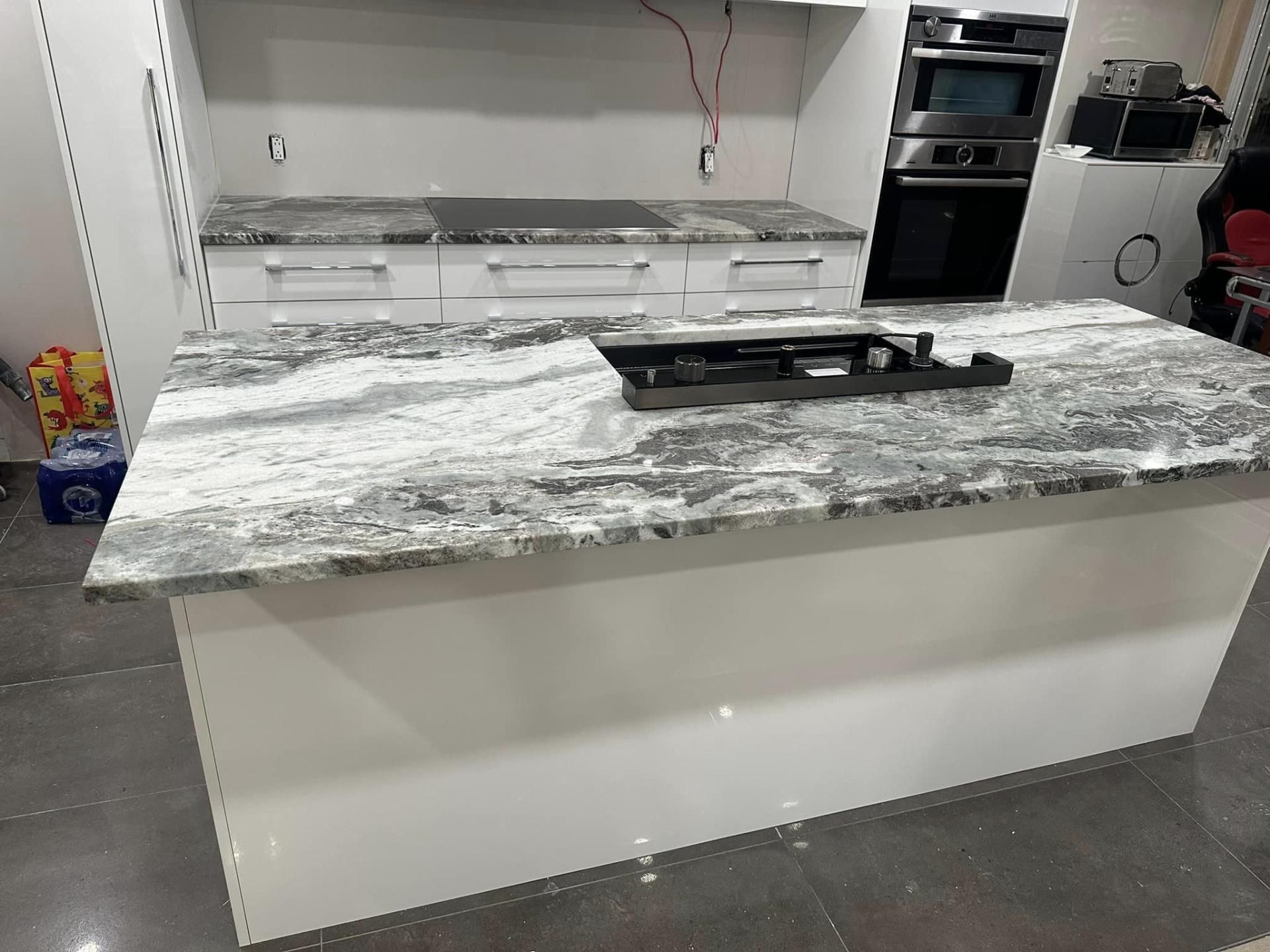 Une cuisine avec un comptoir en granit et une cuisinière avec four.