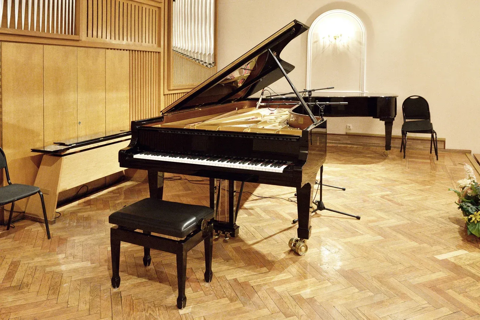A piano is sitting on a wooden floor in a room.
