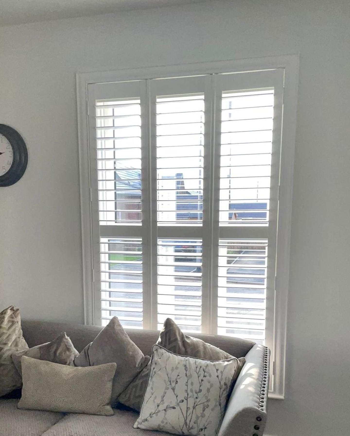 A living room with a couch and a clock on the wall