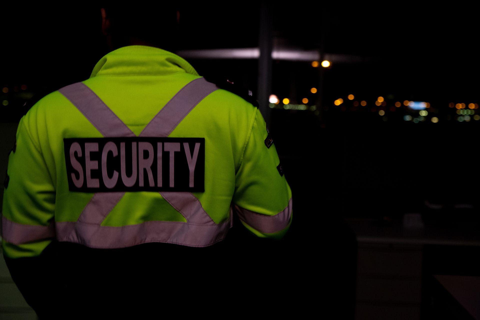 The Back Of A Security Guard Wearing A Neon Yellow Jacket — Coastal Protection Services Pty Ltd In Central Coast, NSW