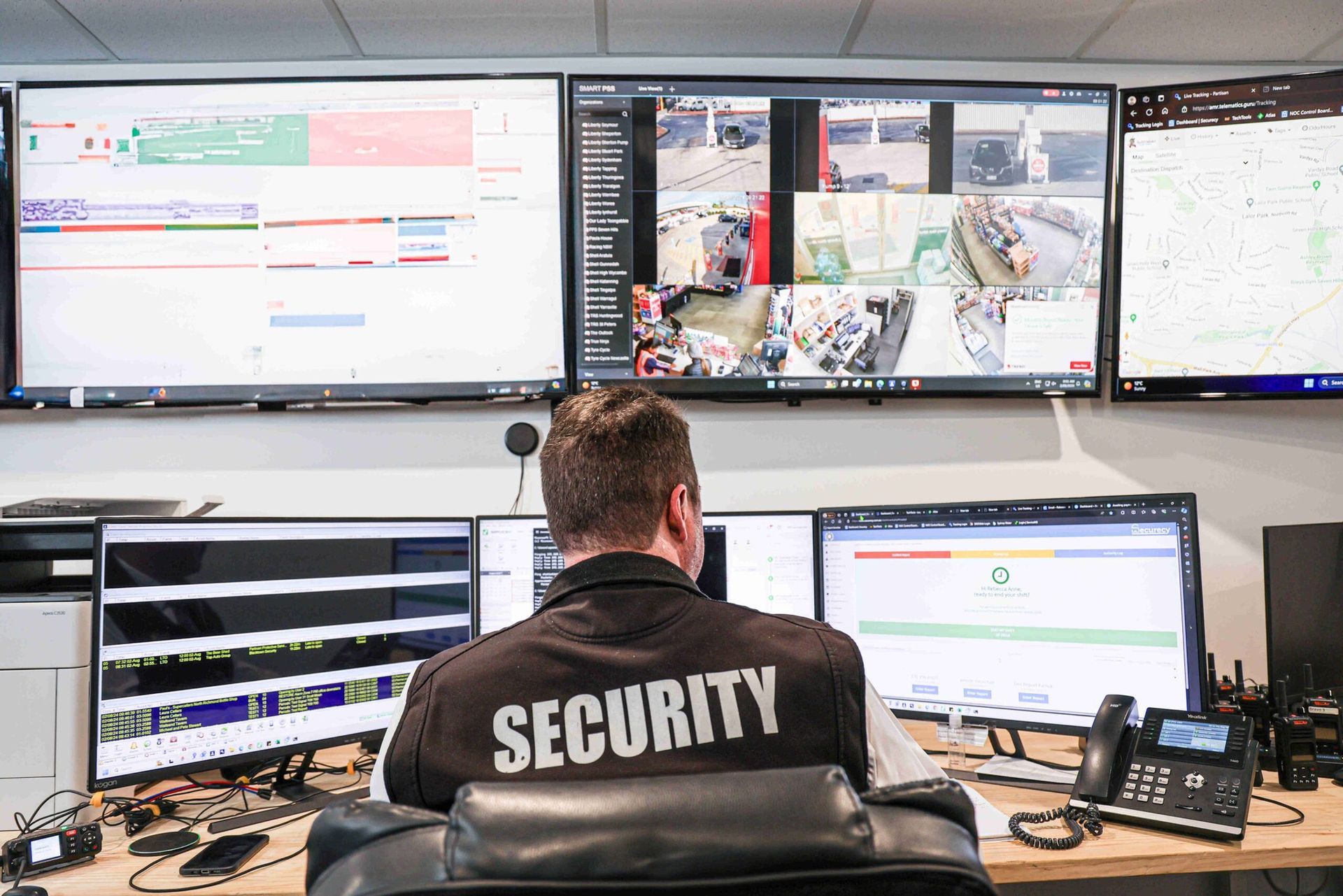 A Man In A Suit Is Talking On A Cell Phone In Front Of A Car — Coastal Protection Services Pty Ltd In Gosford, NSW