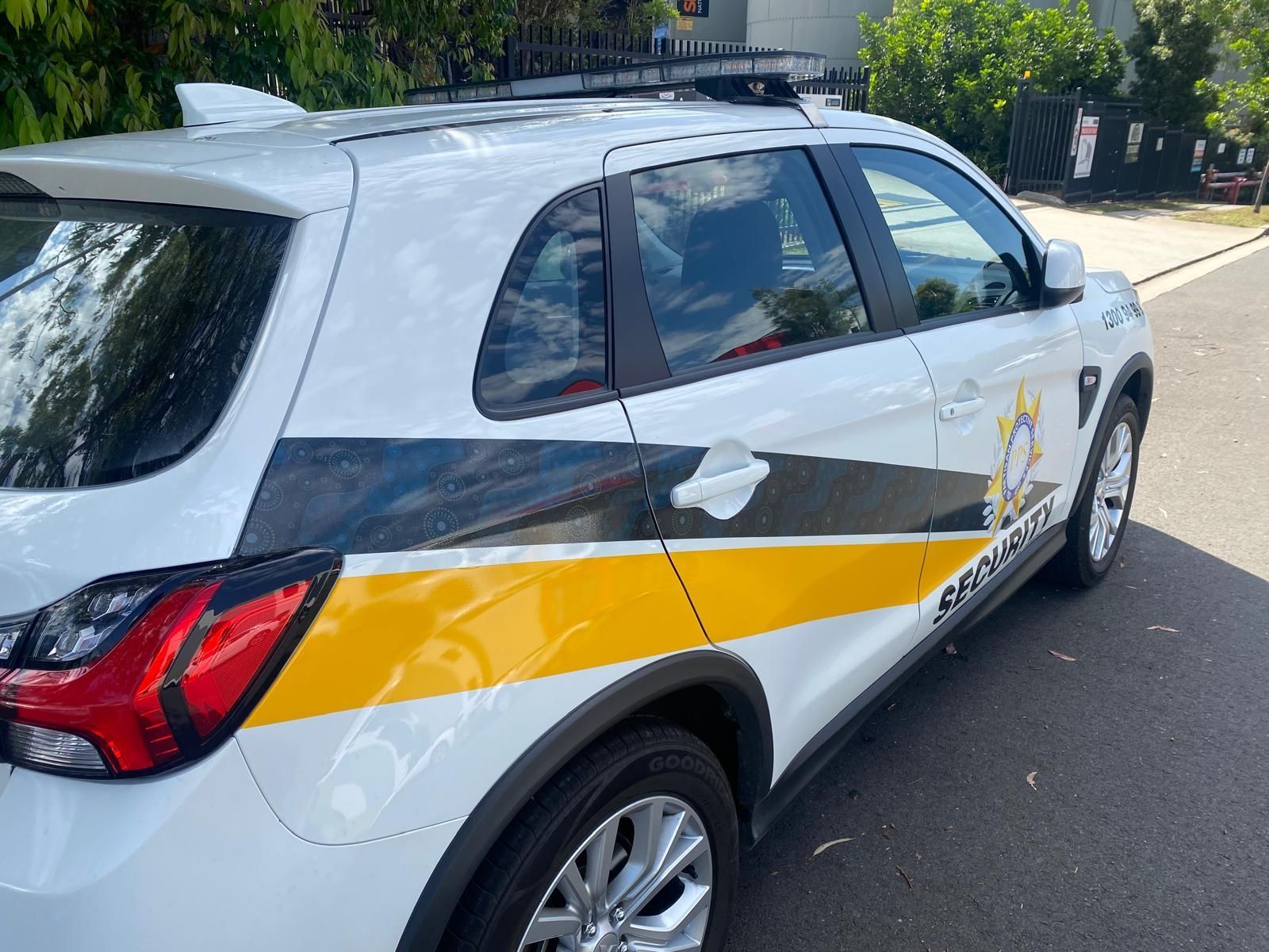 Two Police Cars Are Driving Down The Road — Coastal Protection Services Pty Ltd In Central Coast, NSW