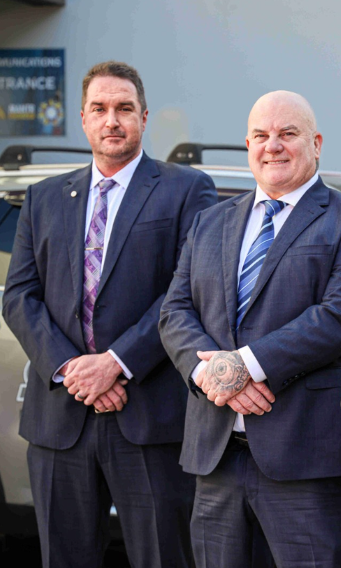 A Security Guard Is Walking With A Walkie Talkie In His Hand — Coastal Protection Services Pty Ltd In Central Coast, NSW