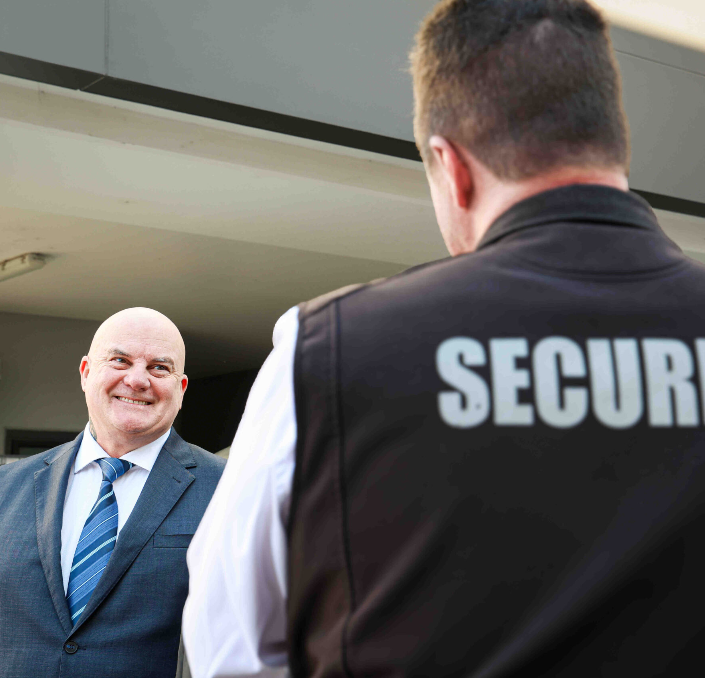 Two Security Guards Are Standing Next To Each Other — Coastal Protection Services Pty Ltd In Blue Haven,NSW