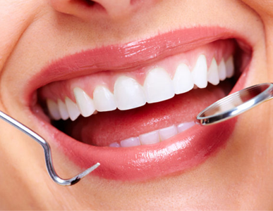 A woman is getting her teeth examined by a dentist