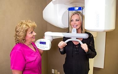 A woman is getting an x-ray of her teeth in a dental office.