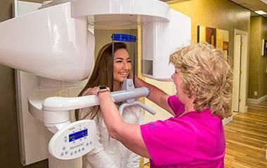 A woman is getting an x-ray of her teeth in a dental office.