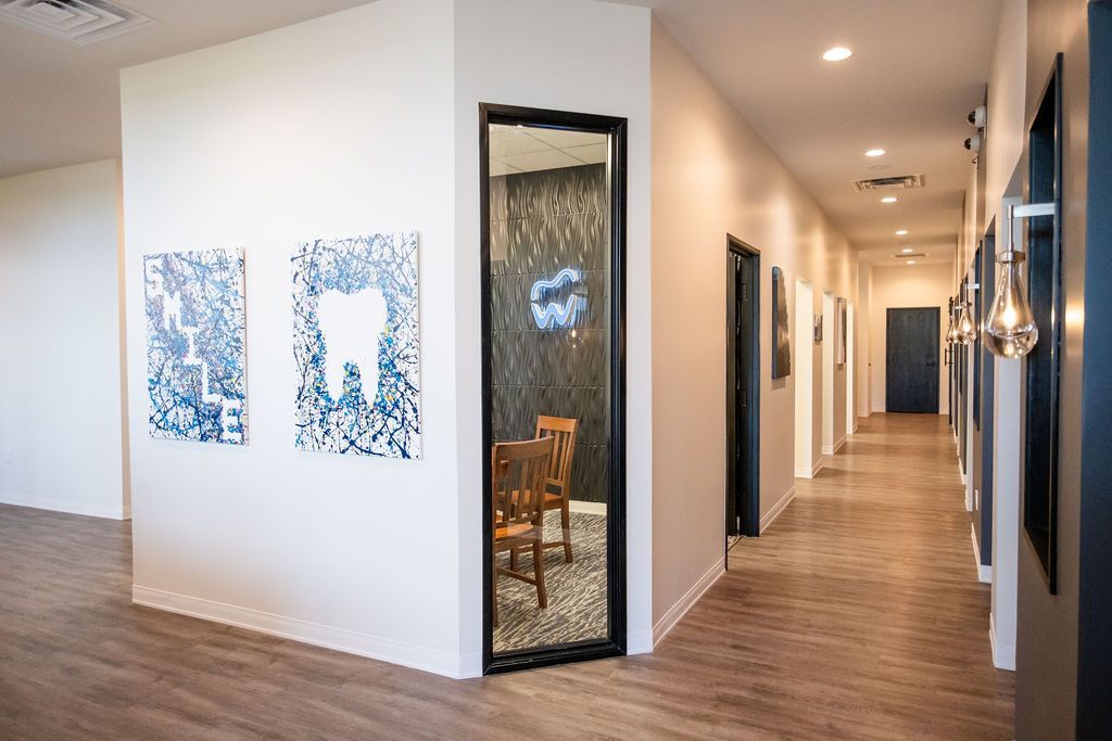 A living room with two couches , a coffee table , and two paintings on the wall.