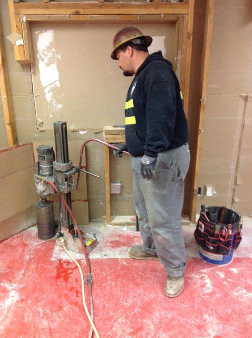 Worker drilling hole in concrete - Concrete drilling services in Milton, WA