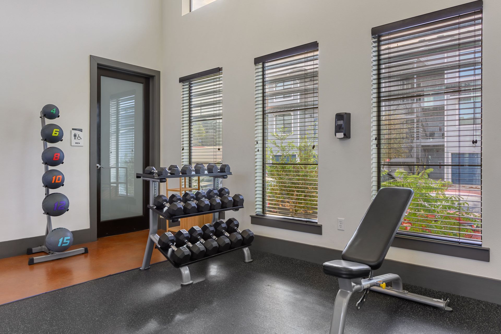 Apartment fitness center with weights and benches at Marquis SoCo in South Austin, TX.