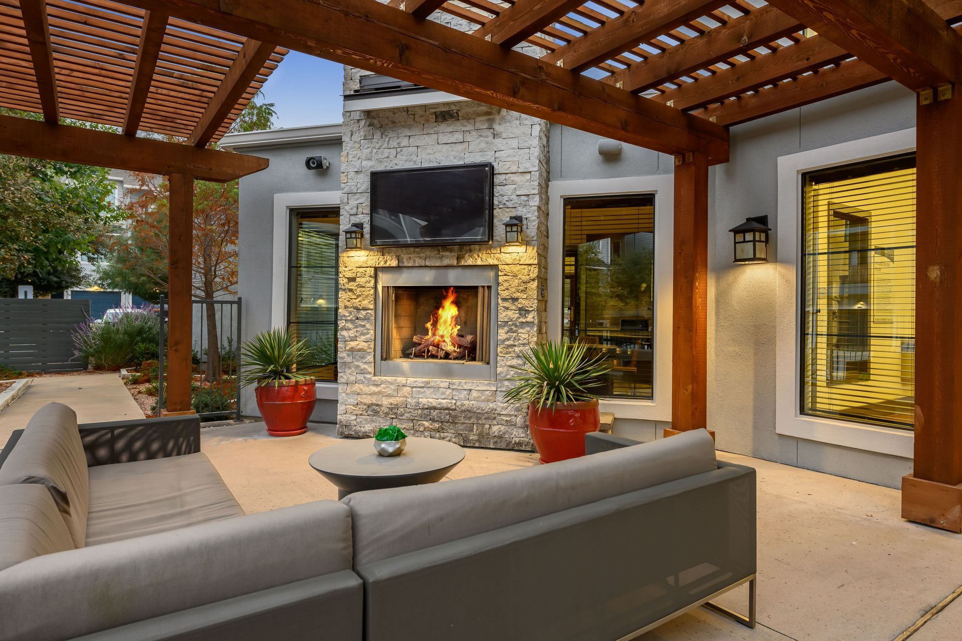 Outdoor fireplace with a television under a pergola at Marquis SoCo in South Austin, TX.