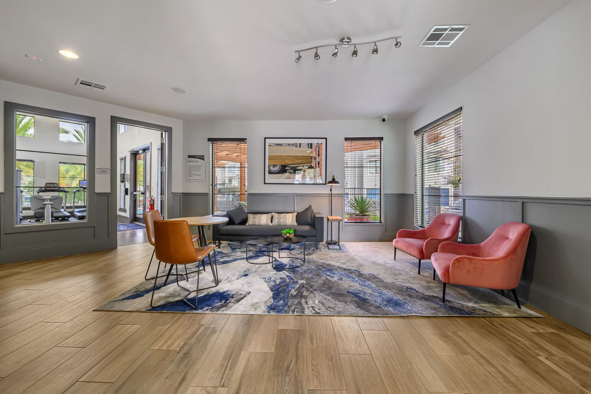 Apartment clubhouse with a couch, chairs, and a rug at Marquis SoCo in South Austin, TX.