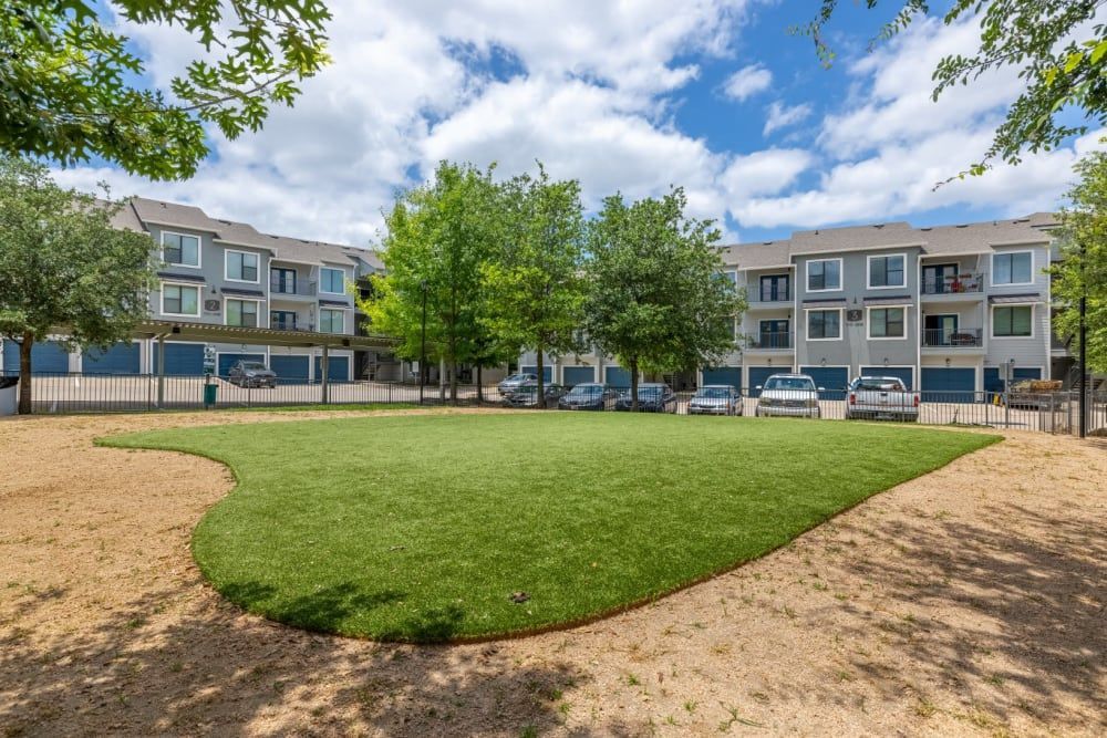 A large grassy area in front of 
 the apartment building at Marquis SoCo in South Austin, TX.