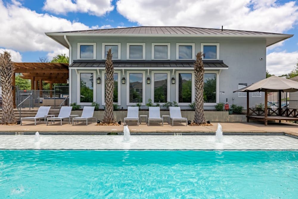 A large white house with a swimming pool in front of it at Marquis SoCo in South Austin, TX.