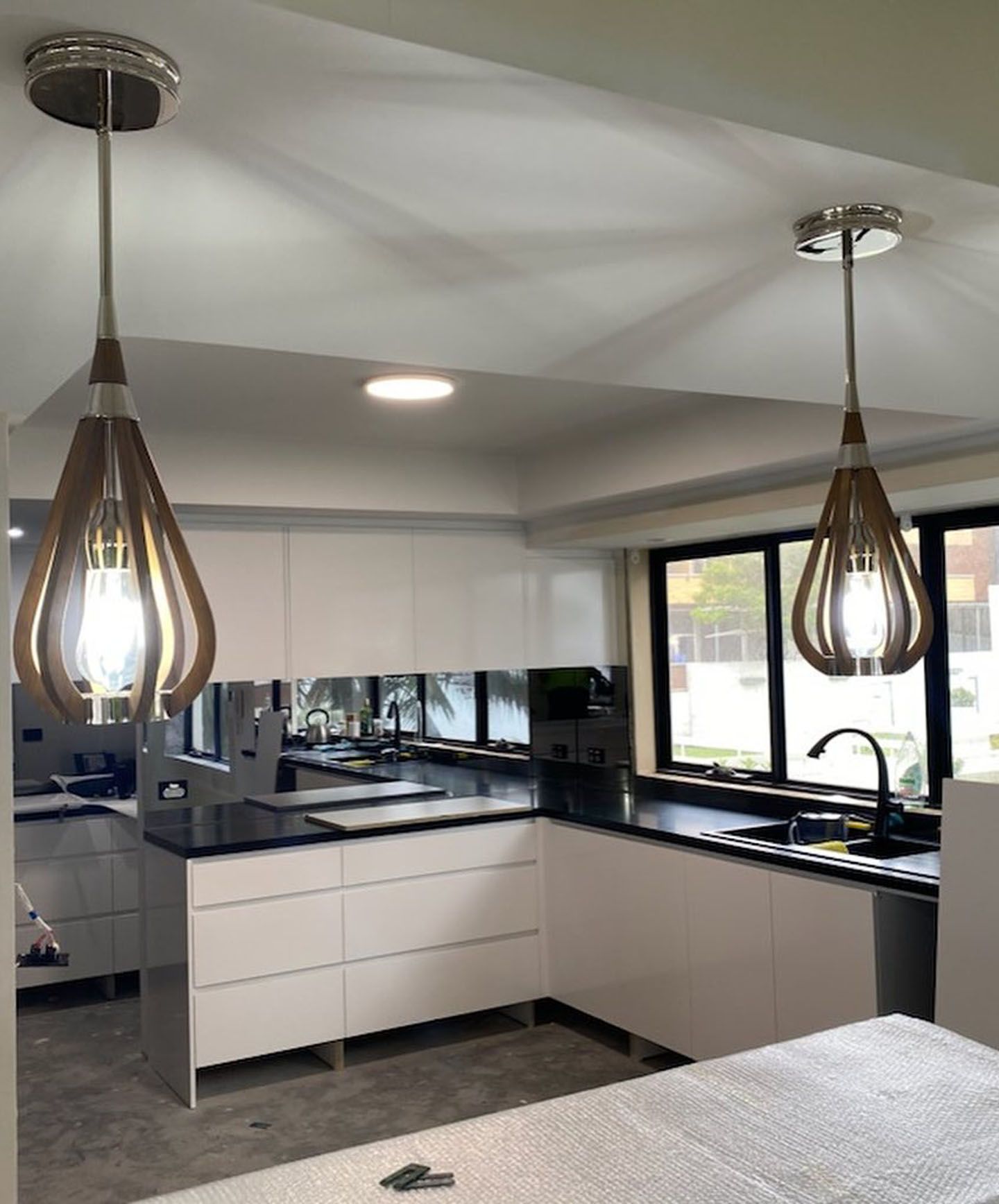 A kitchen with two pendant lights hanging from the ceiling