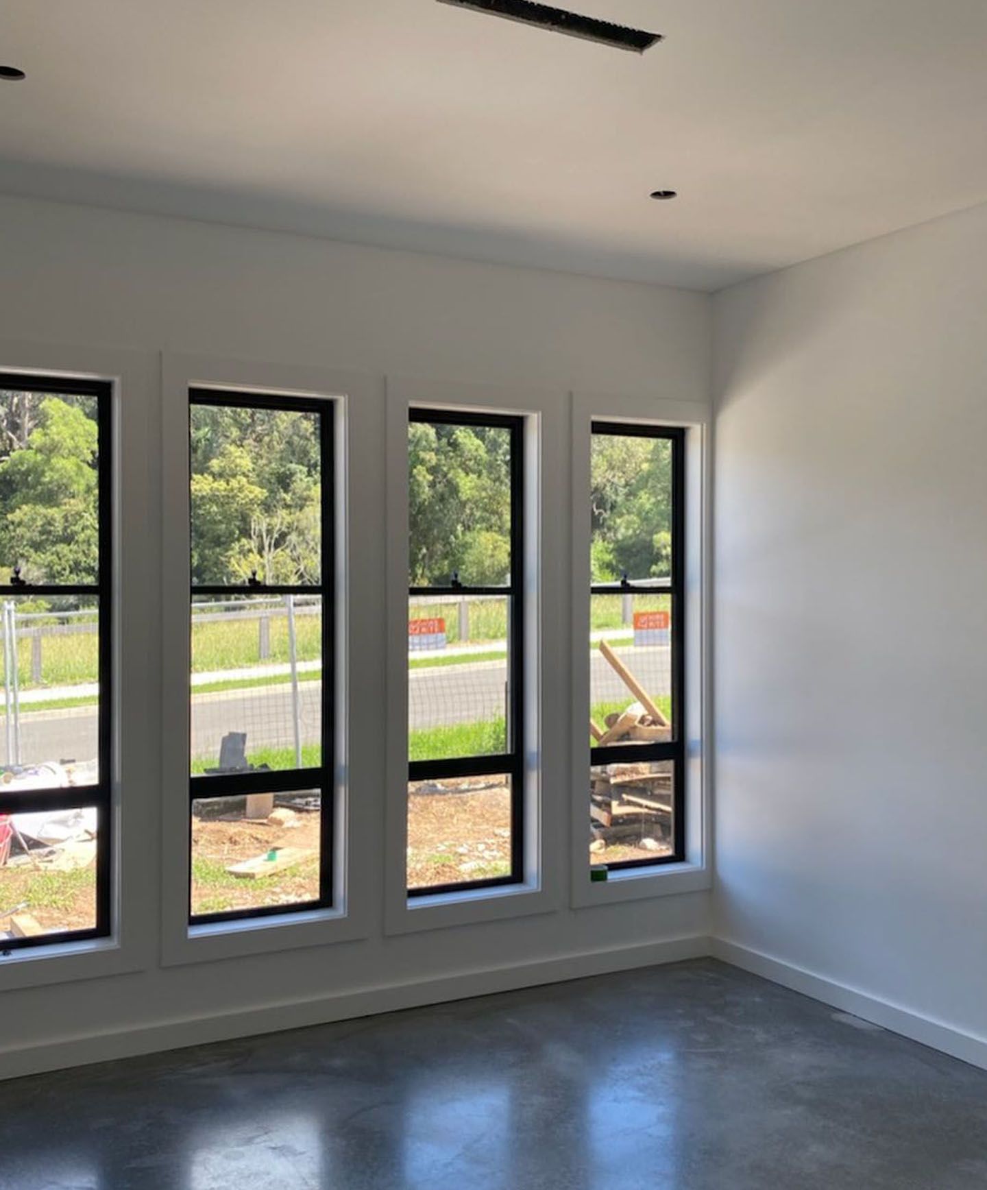 A room with a lot of windows and a concrete floor