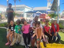 A group of people are posing for a picture while sitting on a bench.