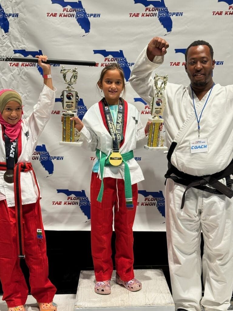 A group of people are standing on a podium holding trophies.