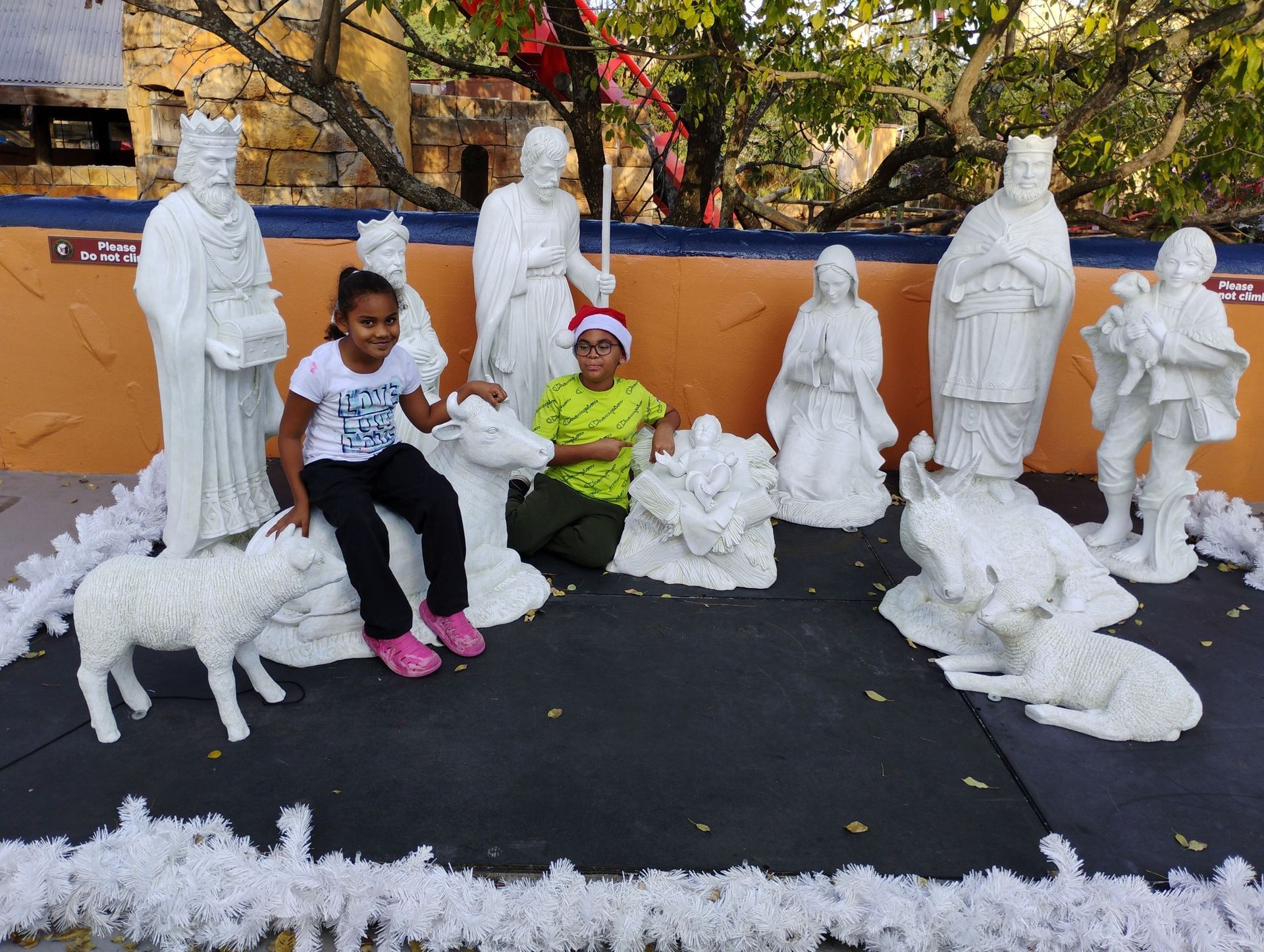 A little girl is sitting in front of a nativity scene