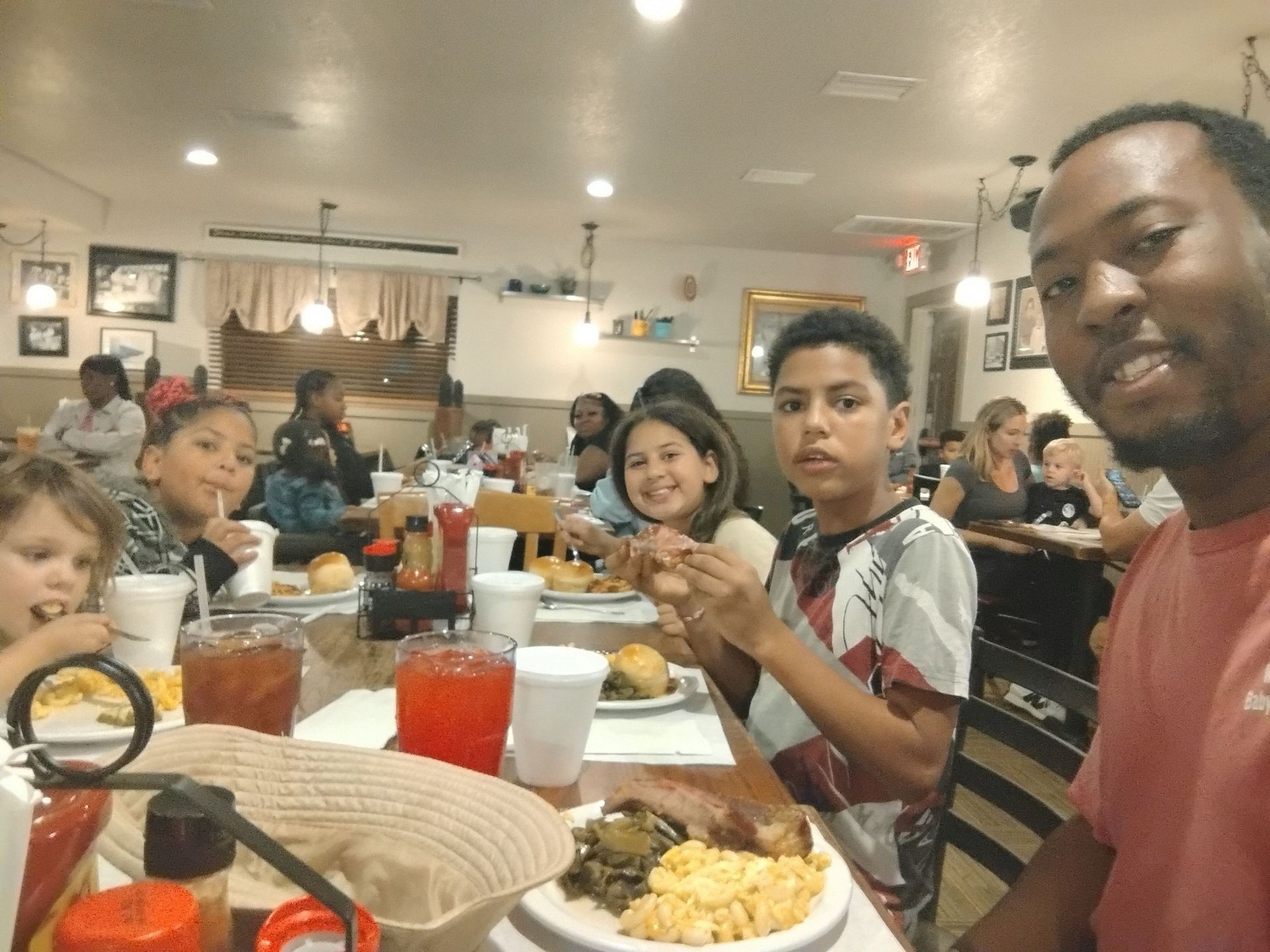 A group of people are sitting at a table in a restaurant eating food.