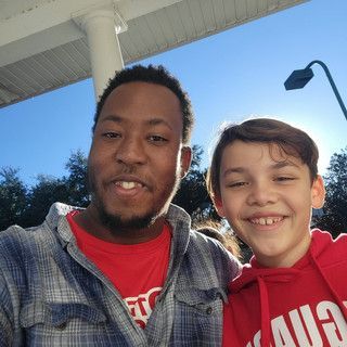 A man and a boy are posing for a picture together.