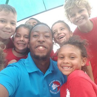 A man is taking a selfie with a group of children.