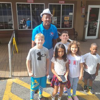 A group of children are posing for a picture in front of a building.