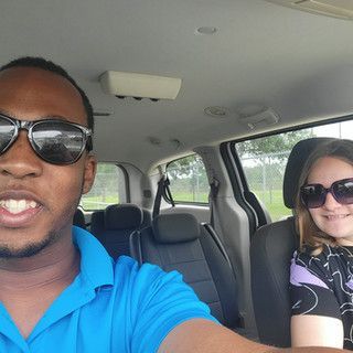 A man and a woman are sitting in the back seat of a car.