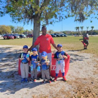 A group of young boys are posing for a picture in a park.