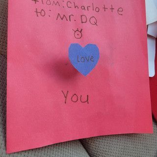 A red piece of paper with a blue heart that says love you