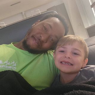 A man and a boy are sitting next to each other on a couch.