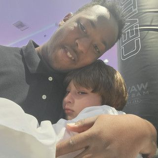 A man is holding a little boy in his arms.