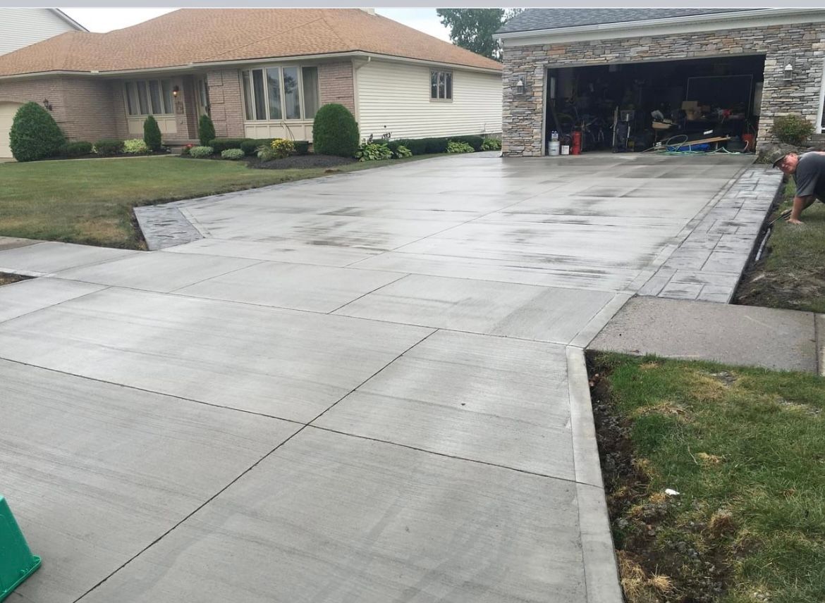 Brushed concrete driveway with subtle texture installed by Universal Paving & Concrete in Rochester, NY, providing durability and a unique aesthetic for residential properties.