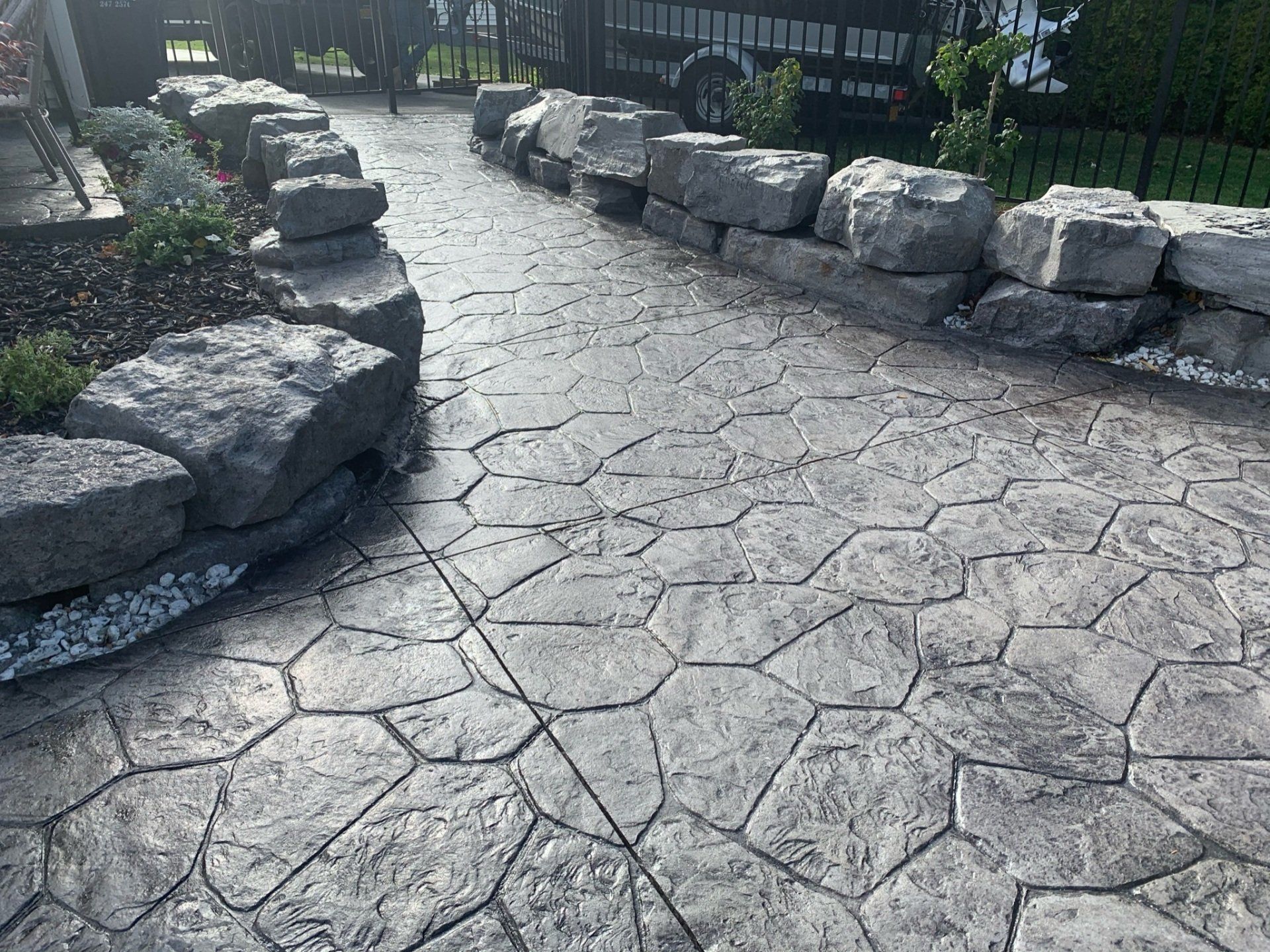 Close-up of a stamped concrete patio with a stone-like texture, designed and installed by Universal Paving & Concrete in Rochester, NY.
