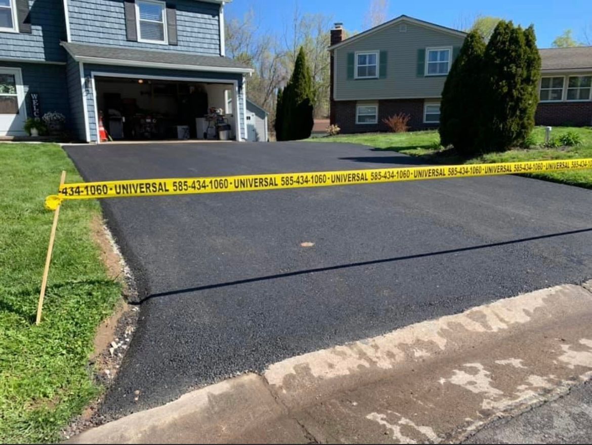 Universal Paving & Concrete installs a high-quality asphalt driveway in Rochester, NY, providing a long-lasting, sleek surface for homeowners.