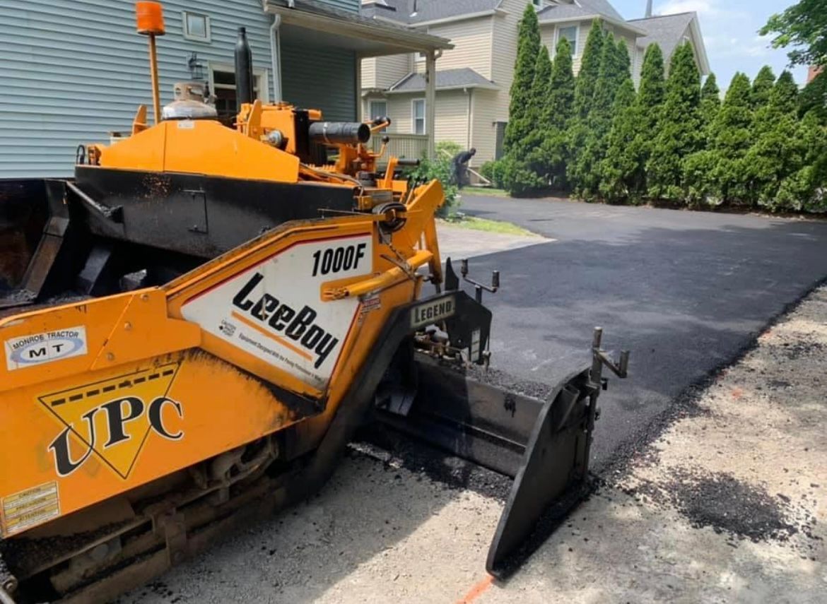 Universal Paving & Concrete team working on an asphalt driveway installation in Rochester, NY, ensuring precise measurements and a high-quality result.