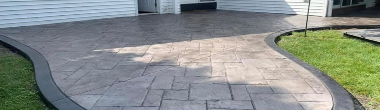 Stamped concrete patio installed by Universal Paving & Concrete in Rochester, NY, showcasing custom design and durability.