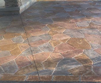 Stamped concrete patio with integrated seating areas and vibrant coloring, installed by Universal Paving & Concrete in Rochester, NY, perfect for entertaining guests.