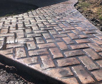 Exquisite stamped concrete patio with a custom pattern and rich color, installed by Universal Paving & Concrete in Rochester, NY, adding value to any home.