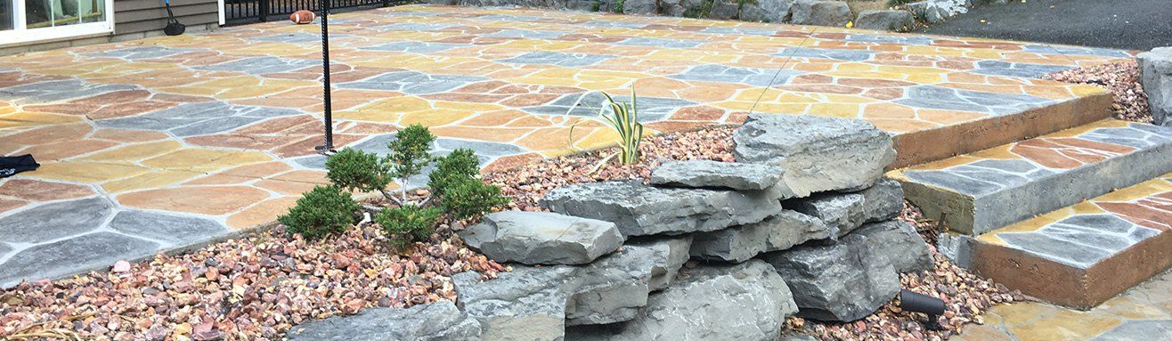 Colored stamped concrete patio installed by Universal Paving & Concrete in Rochester, NY, showcasing custom design, vibrant color, and durability.