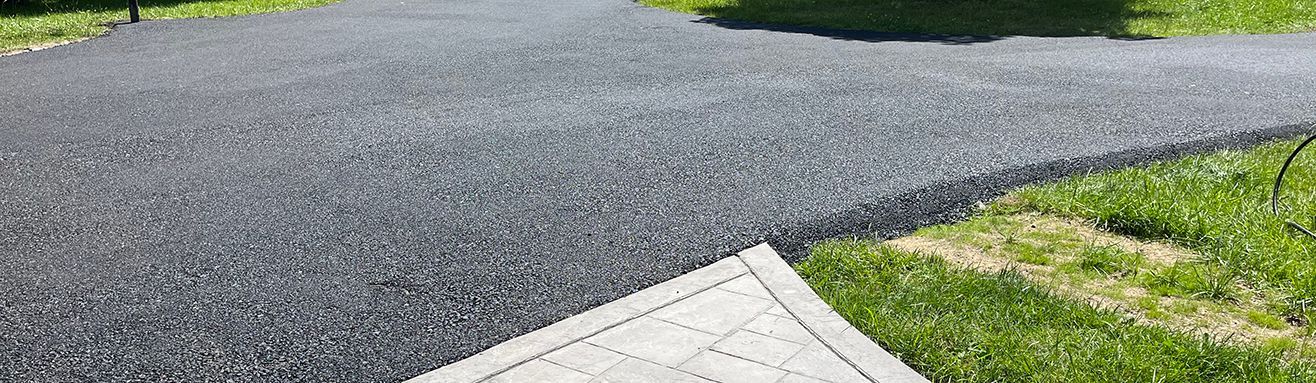 Before and after comparison of an asphalt driveway resurfacing by Universal Paving & Concrete in Rochester, NY, showcasing a clean, updated look.