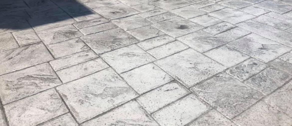 Stamped concrete patio featuring a unique design and rich color installed by Universal Paving & Concrete in Rochester, NY, perfect for outdoor entertaining.