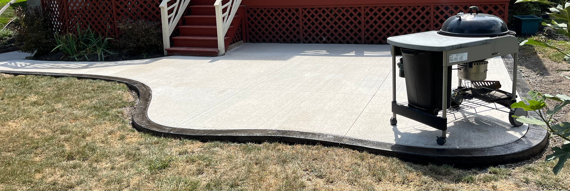Completed brushed concrete patio by Universal Paving & Concrete in Rochester, NY, offering a textured, functional surface that enhances outdoor living spaces.
