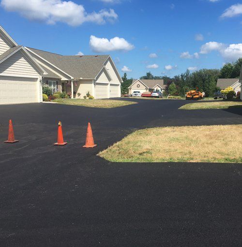Completed asphalt driveway in Rochester, NY by Universal Paving & Concrete, offering a modern, sleek design with enhanced curb appeal.