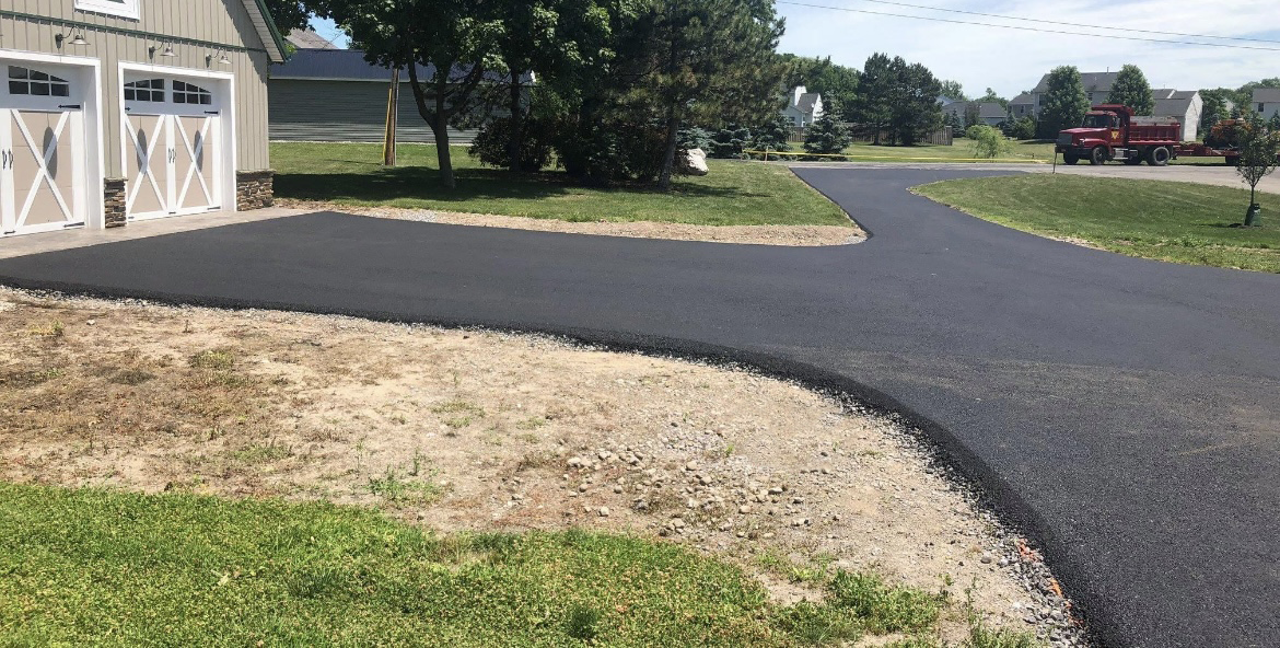 A driveway is being paved in front of a house in Rochester, NY