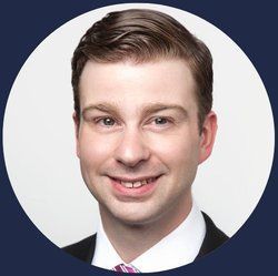 A man in a suit and tie is smiling in a circle.