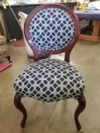 A chair with a black and white pattern on it is sitting on the floor.