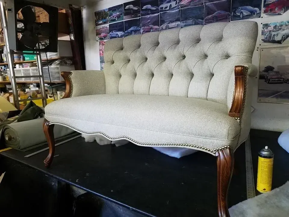 A white tufted couch is sitting on a table in a room.