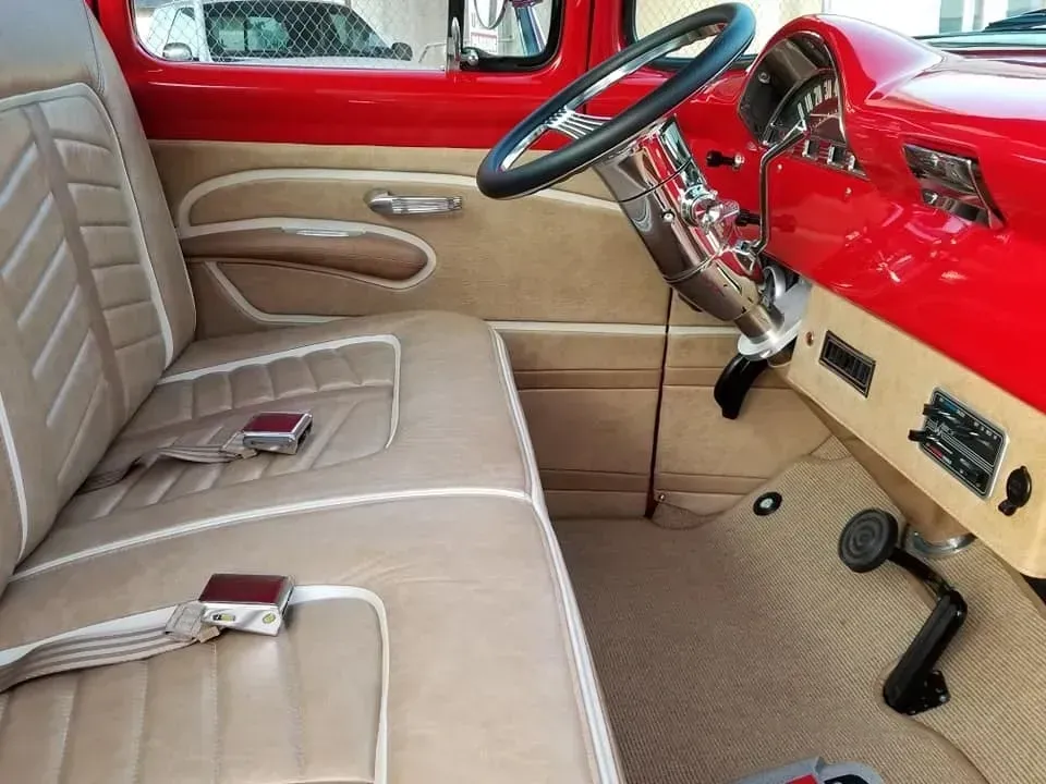 A red truck with tan seats and a steering wheel